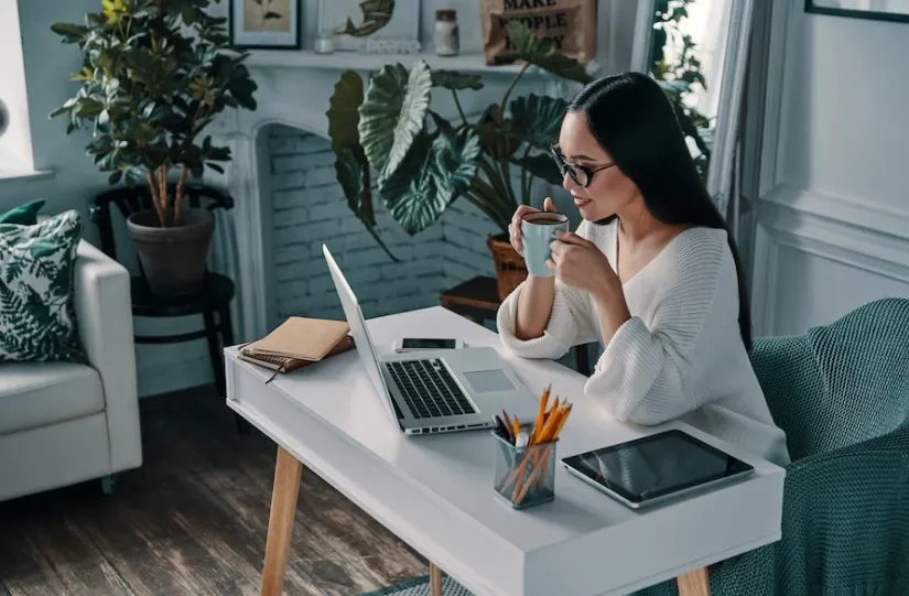 woman having coffee in front of the pc doing home office